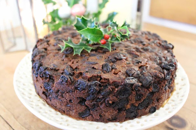 Fruit Christmas cake topped with a holly sprig