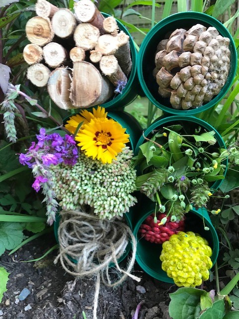 Cans stacked up together and filled with different items to attract bugs and bees