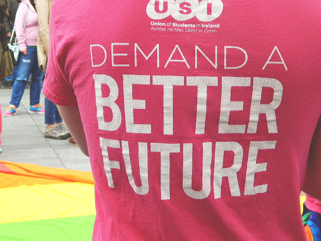 pink shirt reading demand a better future in white text