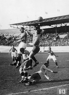 Italia - Uruguay 2-3, 7 giugno 1928. Tra le più grandi partite di Schiavio, per sua stessa ammissione. Nella foto svetta sul leggendario portiere uruguagio Andrés Mazali e su Álvaro Gestido; José Leandro Andrade è a terra; Mario Magnozzi, sulla destra della foto, osserva l'azione. Il pallone colpito da Schiavio finì proprio sui piedi del giocatore del Livorno che, dopo un po' di esitazione, tirò in porta. Andrade riuscì a rialzarsi in tempo e respinse il pallone con la mano facendolo finire in calcio d'angolo. L'arbitro olandese Willem Eymers non concesse né il corner né il calcio di rigore.