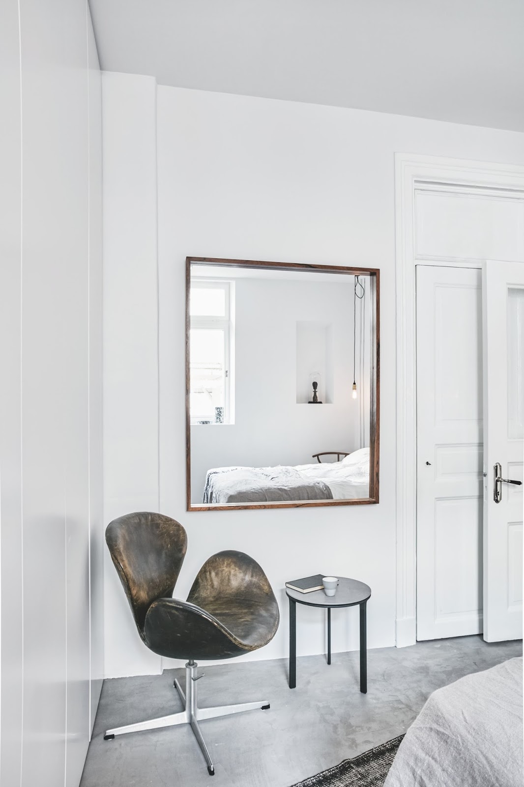 swan chair inside of an minimalist nordic bedroom