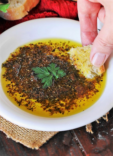 Dipping Bread into Simple Olive Oil Bread Dip Image