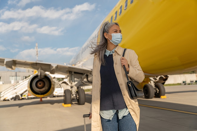 A woman is traveling wearing a mask