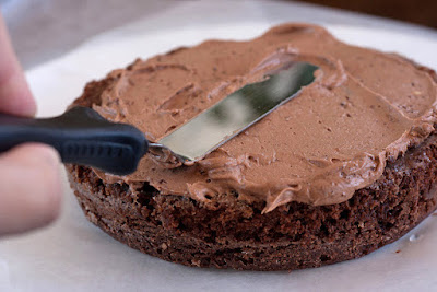 Spread frosting evenly across the top of the cake