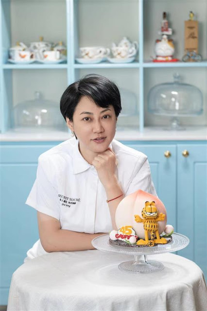 Guo Hong, the owner of the specialty dessert boutique "Secret Sucre" in China, presents a traditional longevity bun cake for Garfield. [Photo courtesy of Paramount Global]