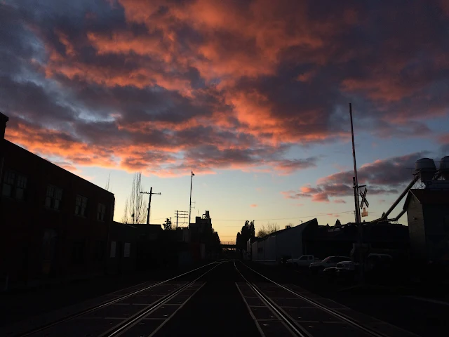 Railroad tracks in West Eugene Oregon with beautiful pink clouds against blue sky