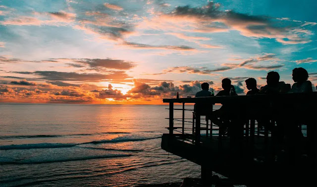 Watching sunset with a glass of cocktail at the Rock Bar bali, indonesia