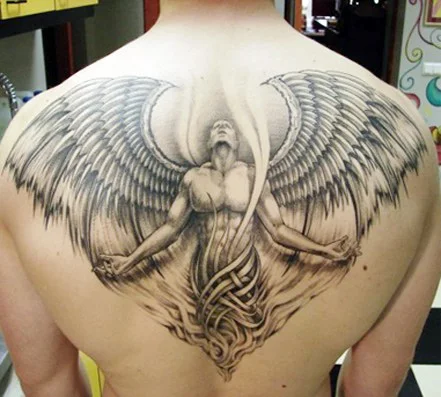 vemos tatuaje de un ángel de la guarda, es un tatuaje realista en tonos grises