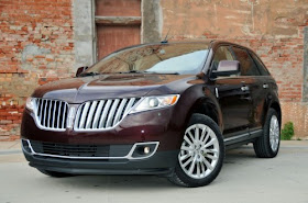 Front 3/4 view of dark red 2011 Lincoln MKX parked in front of brick building