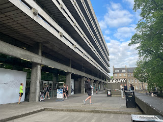 The University of Edinburgh Main Library with runners standing outside.