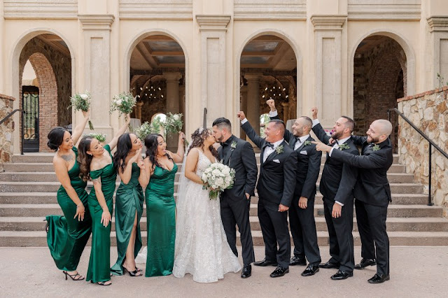 bride and groom kissing with bridesmaids in green and groomsmen in black