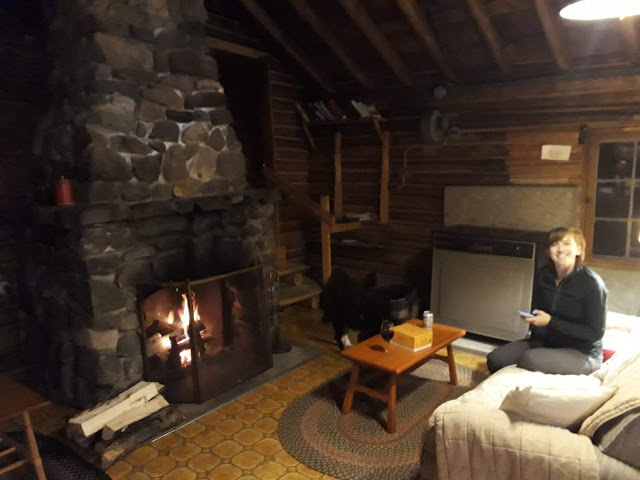 woman in cabin in front of stone fireplace