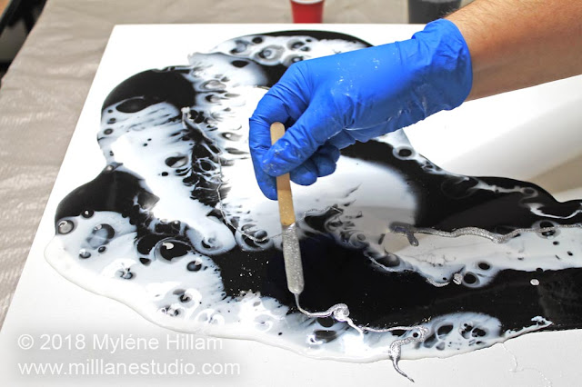 Drizzling silver resin onto the black and white resin.