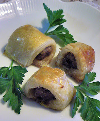 Three sausage rolls on plate with parsley