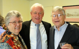 a woman and two men smile at the camera