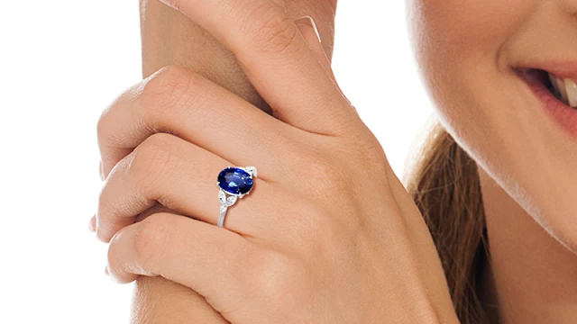 A blue sapphire ring in white gold on a woman’s finger