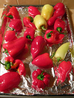 Many shapes and sizes of red and yellow peppers on baking sheet