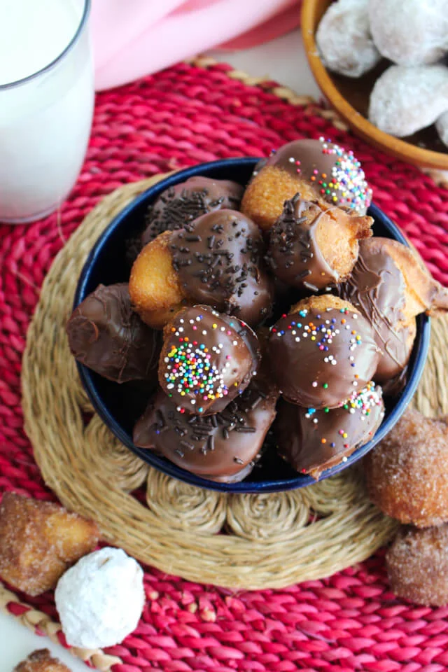 Homemade Drop Doughnuts are the perfect sweet treat for a weekend morning, made with a quick, one-bowl batter that is fried until puffed and golden brown.  Dress your doughnuts up with your favorite toppings like cinnamon sugar, powdered sugar, and chocolate!