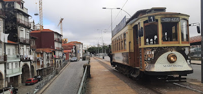 Eléctrico circulando no Porto ao ado de casario