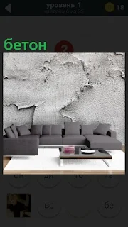В комнате стоит диван, а на стене размазан бетон неряшливо