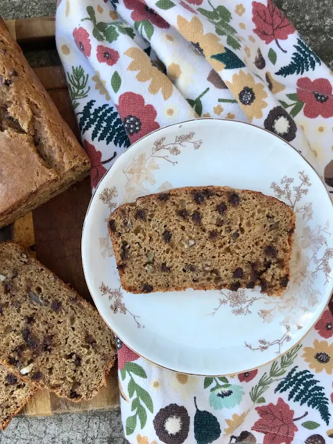 Slice of chocolate chip pecan pumpkin bread on a serving plate.