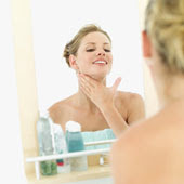 woman applying moisturizer to neck