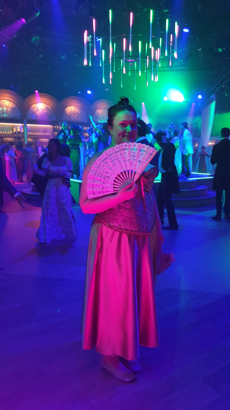 woman standing in the dark room with purple lighting for bridgerton ball