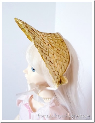 One of the bonnets worn by a bjd (Hikaru).  There is white ribbon on the bonnet that ties in a bow under her chin and matching white roses on the bonnet.