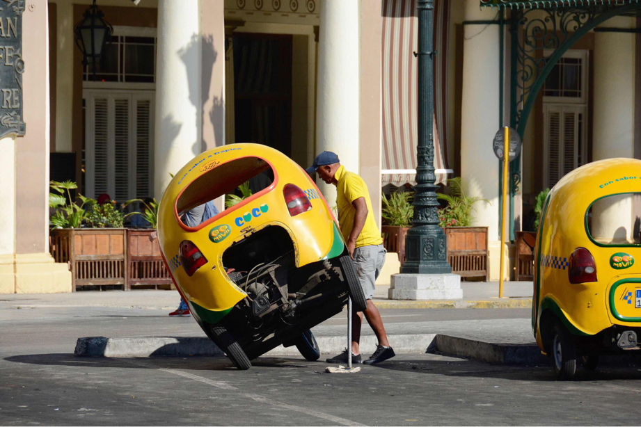 Man lifting up car in Havana Cuba