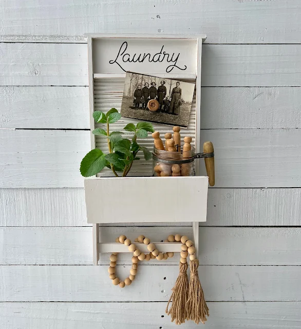 Photo of a thrifted washboard shelf decorated with farmhouse style.