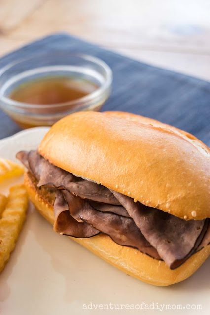 french dip sandwich with au jus sauce and fries