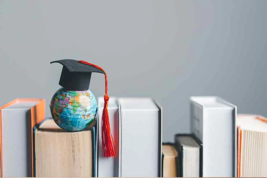 Parents' guide to studying abroad stock image from Canva Pro of a globe wearing a mortar board on some books