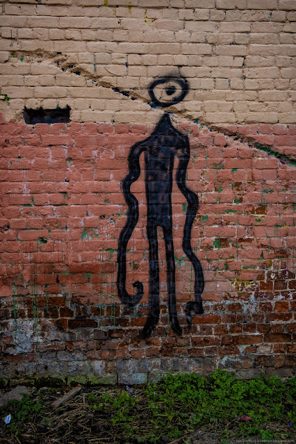 Рисунок абстрактного человека на кирпичной стене