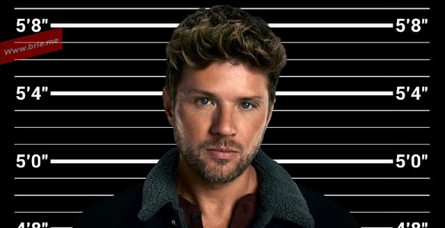 Ryan Phillippe standing in front of a height chart.