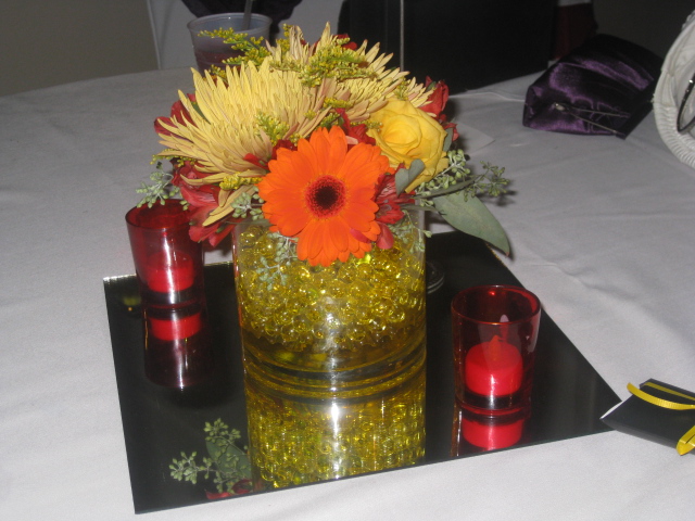 with sashes in red and gold alternating on guest tables centerpieces of