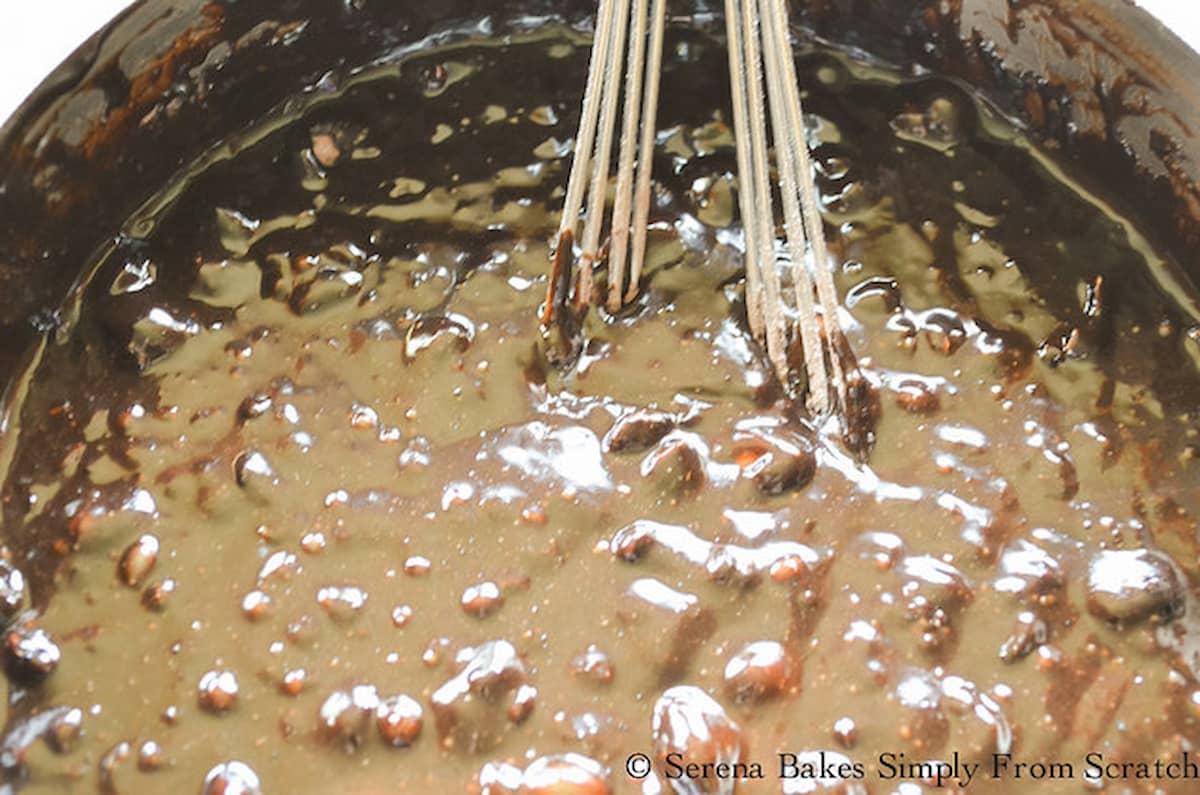 Homemade Brownie batter in a stainless steel pot with a whisk.