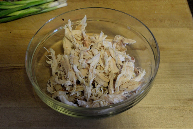 A picture of a bowl with shredded chicken in it.