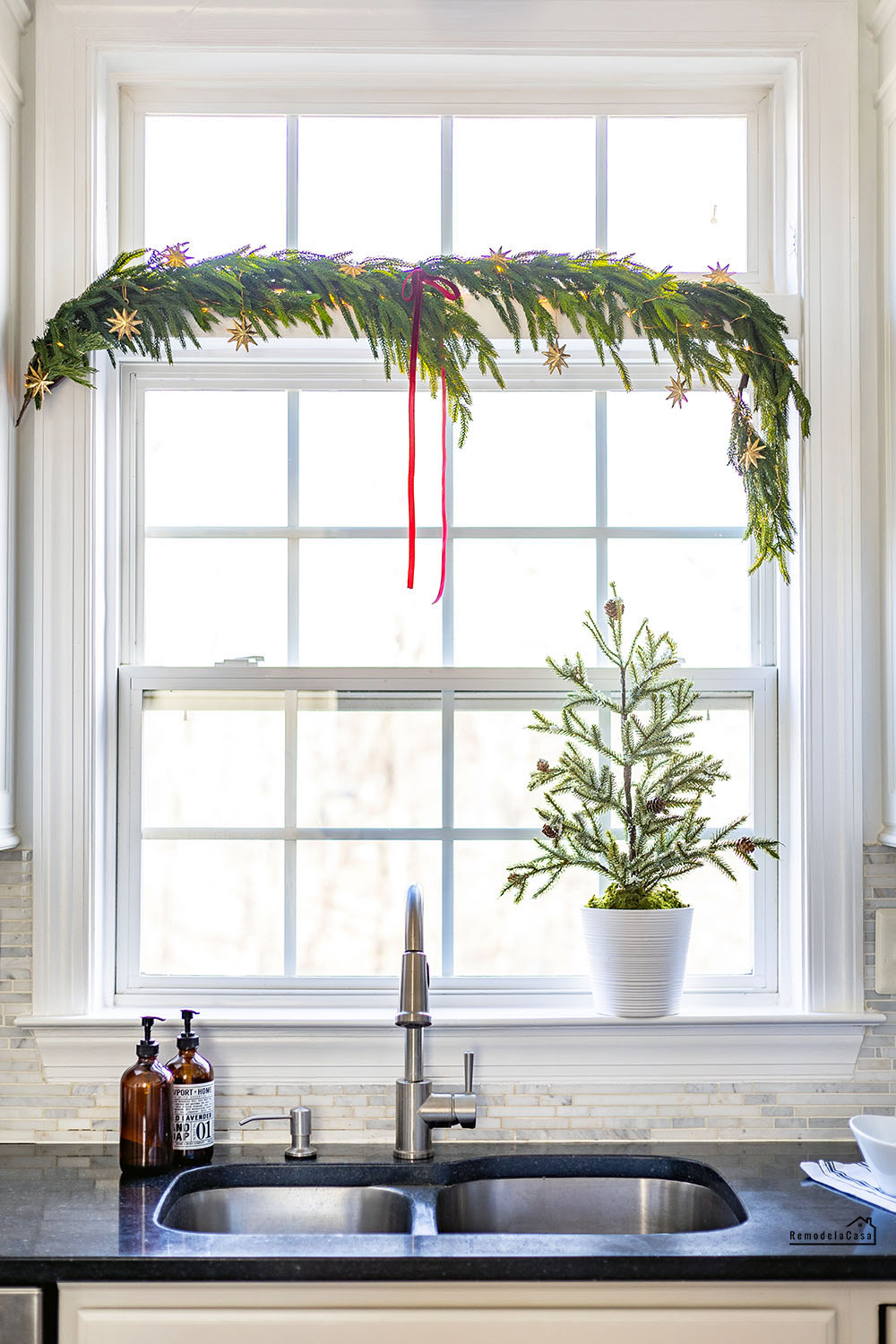 garland and little Christmas tree adorning window