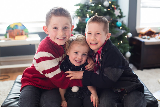 Kids sitting in front of the Christmas tree