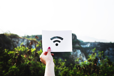 Mujer sosteniendo una tarjeta blanca en la que se ve un icono de WiFi