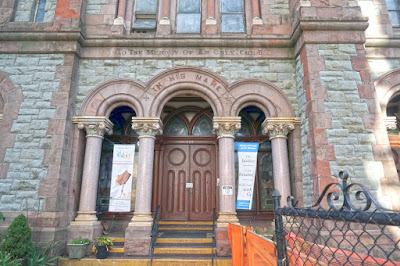 Chapel entrance featuring three stone arched openings in front of a decorative wood door