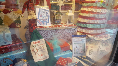 one of the storefront windows at Emma's Quilt Cupboard and Sewing Center