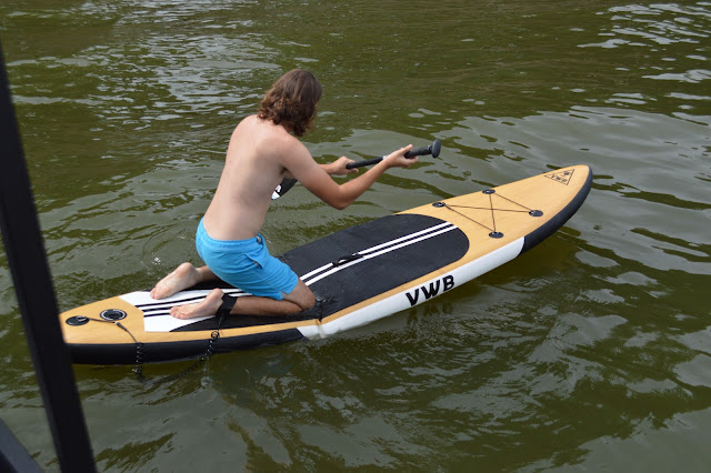 Andy kneeling on the paddleboard.