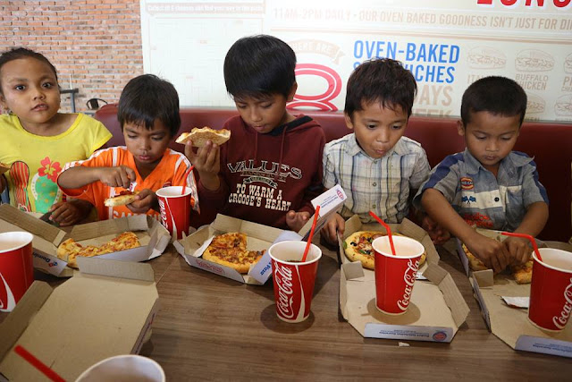 Kids of Shanty Town having pizzas