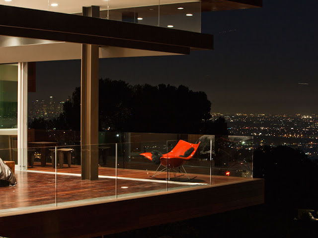 Picture of the red chair on the terrace and city lights in the background