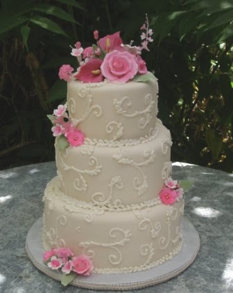 Three tier white wedding cake with gorgeous pink roses sugar calla lilies