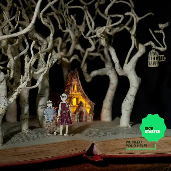 altered book art scene with trees, tiny house and boy and girl made of book page paper