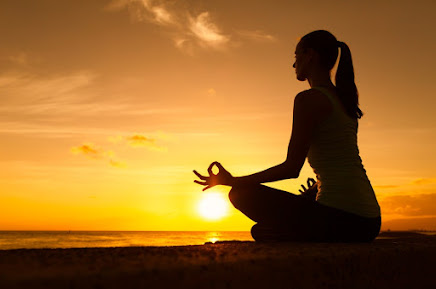 Mulher meditando ao por do sol