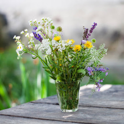 picking some wild flowers and putting them in a glass on a low budget