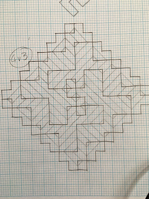 A spiral motif formed from intersecting diagonal lines, drawn in pencil on graph paper with horizontal and vertical mirror lines drawn in and surrounded by 4x4 boxes